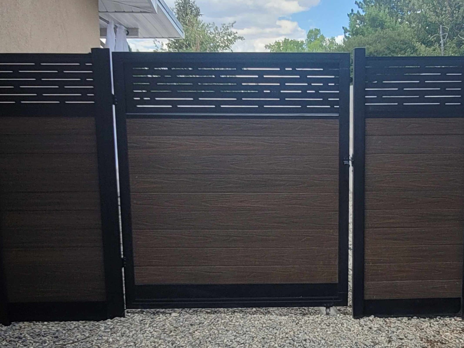 Modern fence with gate installed in front of a home