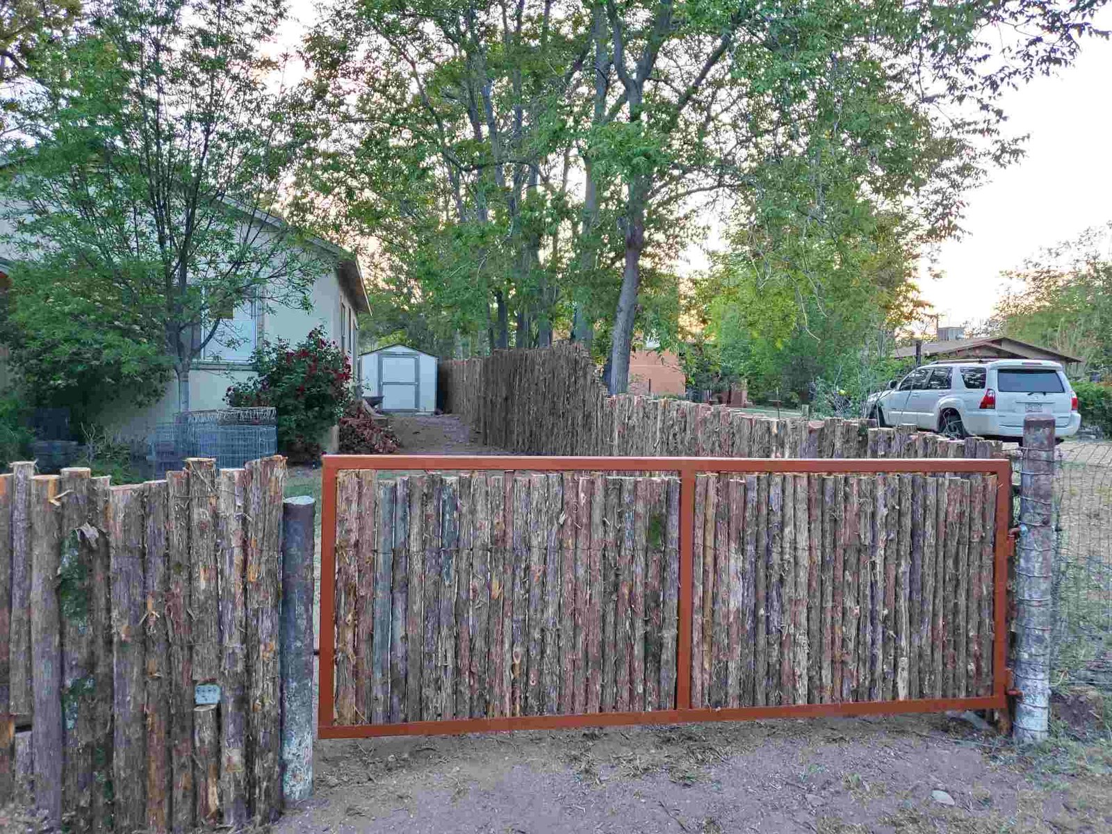 Rustic wooden fence with a metal gate entrance