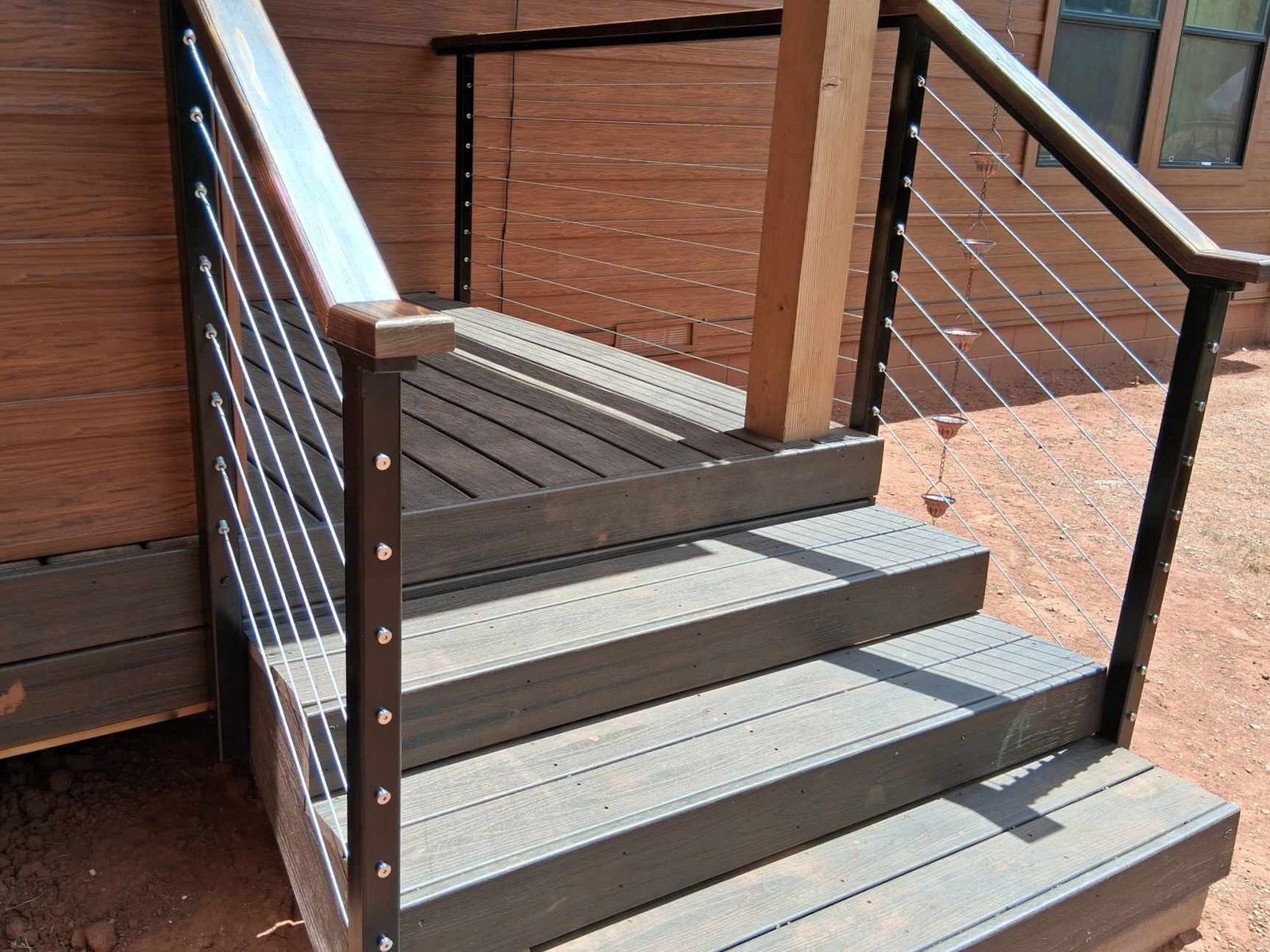 Wooden staircase with railing leading up to a home entrance